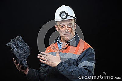 Coalminer holds out a large chunk of energy rich Stock Photo