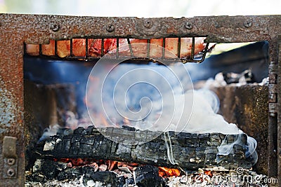 coals and smoke in fire. Meat steaks on a grill rack cooking over an open fire Stock Photo