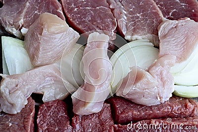 Coarsely chopped pieces of beef, pork, chicken, onion. The concept of cholesterol food. Raw meat before cooking Stock Photo