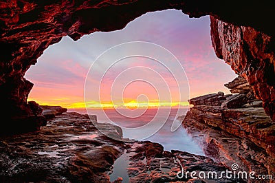 Coastal cave views to glorious sunrise over the ocean Stock Photo