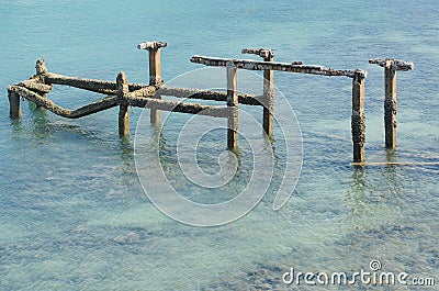 Old harbor ruins in the blue sea Stock Photo