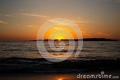 Coastal Sunset Splendor: Orange Skies and Waves in Punta del Este Stock Photo