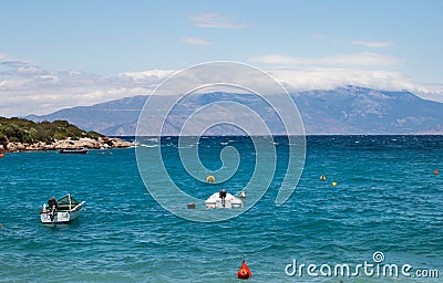 Coastline of beautiful Mediterranean sea with motor boats with thick clouds, Greece Stock Photo
