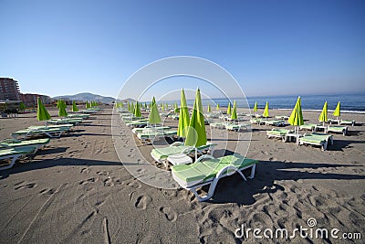 Coastline landscape with rows of empty sunbeds Stock Photo