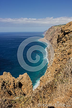 Coastline of Madeira with high cliffs along the Atlantic Ocean. Blue Sky Stock Photo