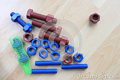 Coated stud bolt and nut on wood texture Stock Photo