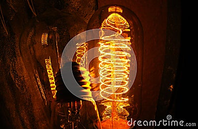 Cobbled classic incandescent Edison light bulbs with visible glowing wires in the night Stock Photo