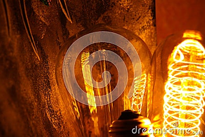 Cobbled classic incandescent Edison light bulbs with visible glowing wires in the night Stock Photo