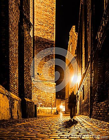 Cobbled street of Old Town with dark blurred silhouette of person. Evokes Jack the Ripper Stock Photo