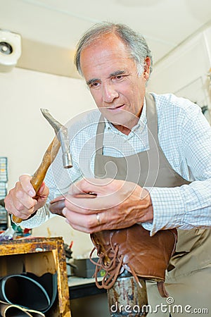 Cobbler hammering sole boot Stock Photo