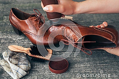 Cobbler holding shoe and applying shoe shiner Stock Photo