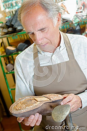 Cobbler holding shoe with no sole Stock Photo