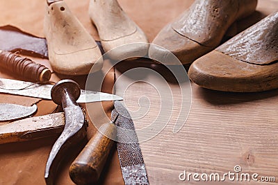 Cobbler tools in workshop on the wooden table . Space for text. Stock Photo