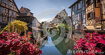 Cobblestone street in picturesque Alsace village with half timbered houses and beautiful flowers. Stock Photo