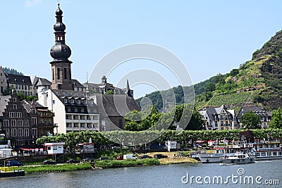 Cochem, Germany - 06 17 2021: old town with ship departure and a small boat passing Editorial Stock Photo