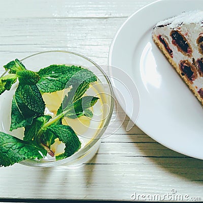 cocktail with lemon and mint, cherry-chocolate cake on a white background Stock Photo