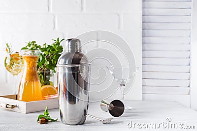 Cocktail shaker, swizzle, tongs and spoon with ice in a bucket for preparing a summer cocktail Stock Photo