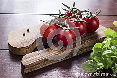 Cocktail tomatoes and basil on wooden board Stock Photo