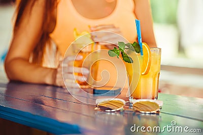 Cocktail in woman hand on the open terrace in bar during summer time Stock Photo