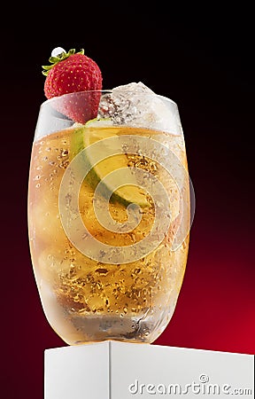 Cocktail with yellow liquid with fruit, strawberry, lime Stock Photo