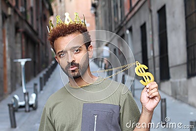 Cocky guy wearing crown and dollar-sign necklace Stock Photo