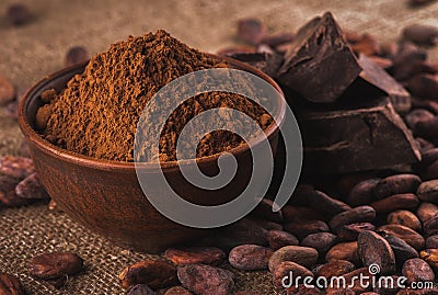 Cocoa powder in a brown ceramic bowl, raw cocoa beans in the pee Stock Photo