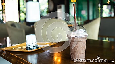 Cocoa Smoothie in glass on wooden table with blur interior coffee shop. Stock Photo