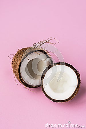 Coconut. Broken coconut on pink background.Two coconut halves. Copyspace Stock Photo