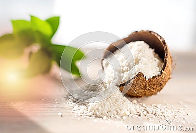 Coconut flakes lies in a coconut shell, cut into two halves Stock Photo