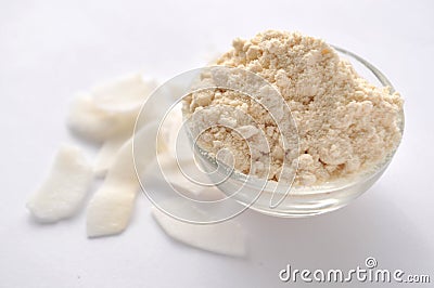 Coconut flour and flakes on white background. Cream powder in a glass bowl. Isolated on white. Alternative gluten-free flour Stock Photo