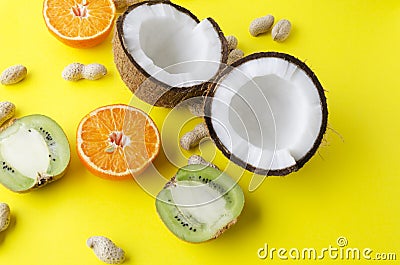 Variety of healhy meal on yellow background.Kiwi fruit,coconut,orange,peanuts Stock Photo