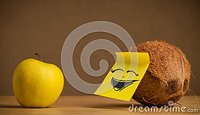 Coconut with post-it note laughing on apple Stock Photo