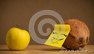 Coconut with post-it note sticking out tongue to apple Stock Photo