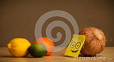 Coconut with post-it note watching at citrus fruits Stock Photo