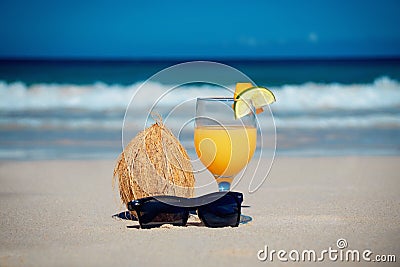 Coconut, cocktail and glasses by the ocean Stock Photo