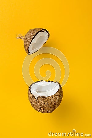 Coconut on yellow colored background, minimal flat lay style. Stock Photo