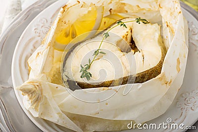Cod fillets baked in parchment paper with slices Stock Photo