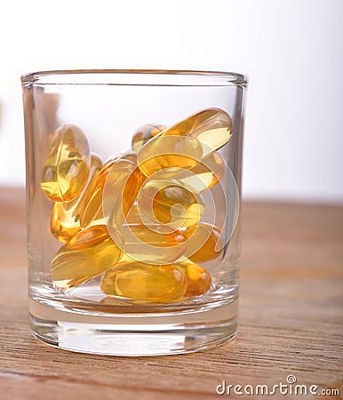 Cod liver fish oil omega 3 gel capsules in glass Stock Photo