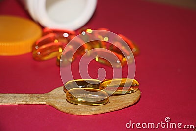 Cod liver fish oil omega 3 gel capsules on red background. Healthcare concept Stock Photo