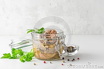 Cod liver in a jar with parsley and pepper on white background. Natural source of omega 3 and vitamin D. close up Stock Photo