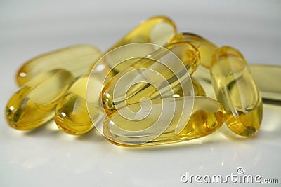 Cod liver oil capsule pill stack together. Close up fish oil pills on the white plate Stock Photo