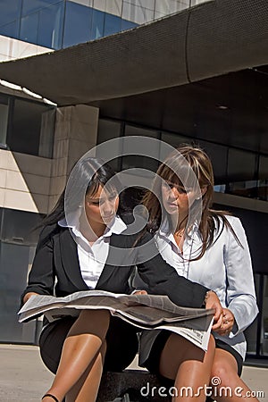 Coeds looking at a newspaper Stock Photo