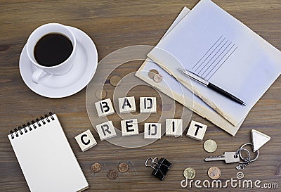 Coffe, pen, money and blocknot on a desk and text Bad Credit Stock Photo