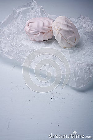 Coffe and strawberry flavoured zephyr on white paper, light background. Low fat dessert, carbohydrate food, soft sweets, tasty Stock Photo