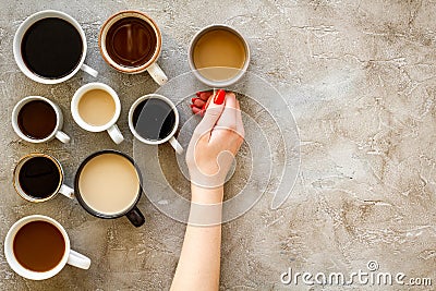 Coffee addiction. Mug in hand, many cups on grey background top view copy space Stock Photo