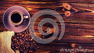 Coffee beans and a cup of coffee on a wooden background. Stock Photo