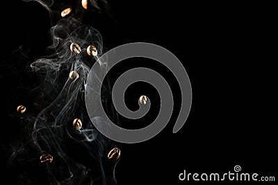 Coffee beans falling down trough smoke over black background - isolated Stock Photo