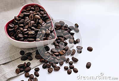 Coffee beans poured into a small Cup in the form of a heart Stock Photo