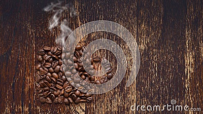 Coffee beans on a wooden table with steam Stock Photo