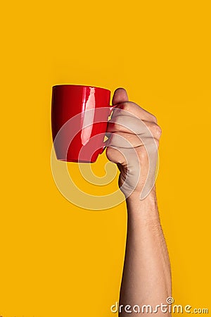 Coffee break. Closeup of man holding cup with aromatic drink on orange background Stock Photo